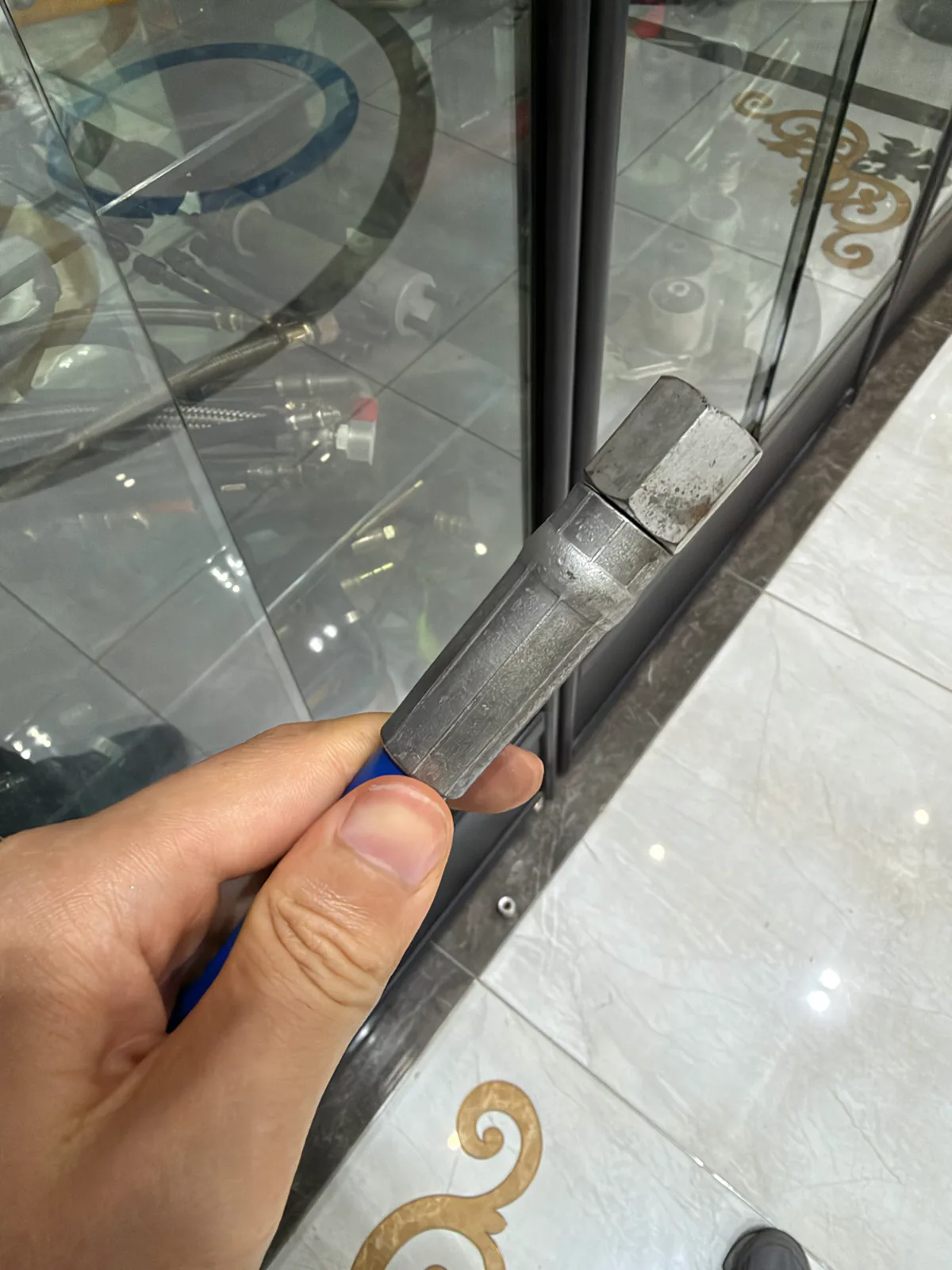 手持黑色管体和金属接头的剖面/半成品,可见管体与接头结合区域